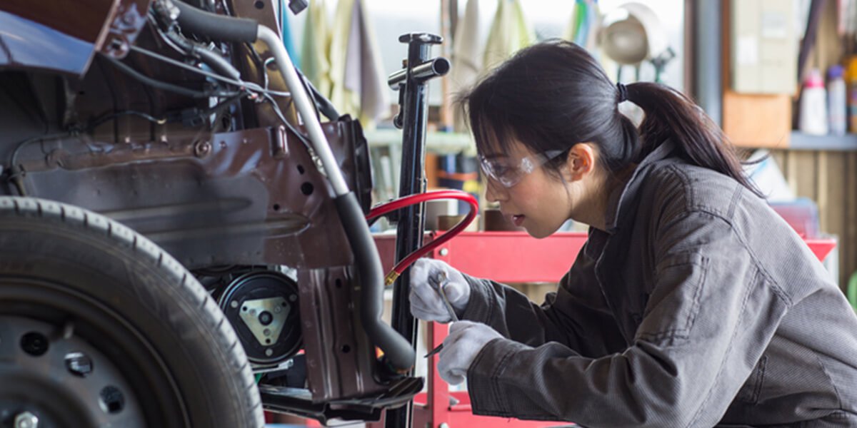 female mechanic fixing car - best auto insurance coverage mamoroneck ny